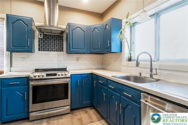 2103 N 1st Ave, Whitehall Twp, PA 18052 - kitchen featuring stainless steel appliances, island range hood, light wood finished floors, and blue cabinets