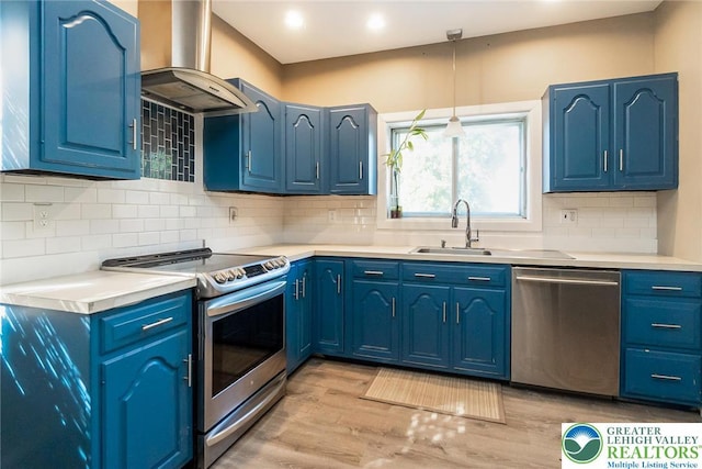 2103 N 1st Ave, Whitehall Twp, PA 18052 - kitchen with appliances with stainless steel finishes, island range hood, light countertops, light wood finished floors, and blue cabinets