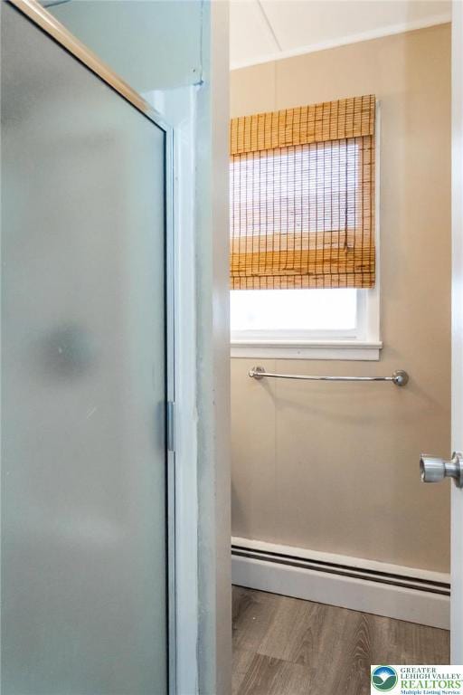 2103 N 1st Ave, Whitehall Twp, PA 18052 - full bath featuring a baseboard heating unit, a shower with shower door, and wood finished floors
