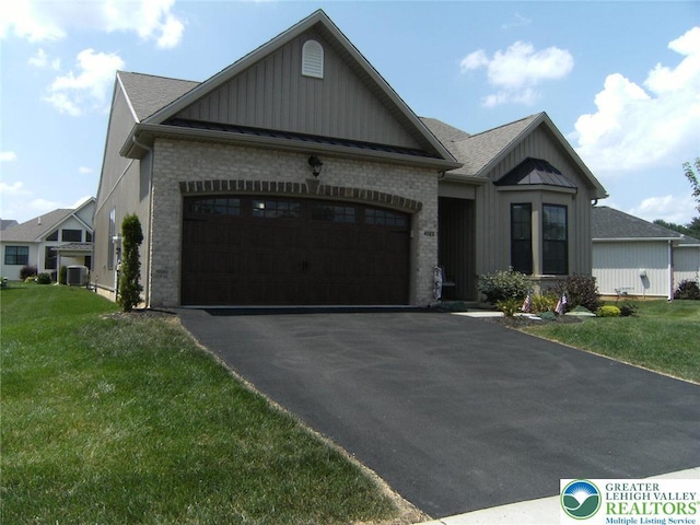 4088 Eveningstar Rd, Emmaus Boro, PA 18049 - view of front facade with an attached garage, board and batten siding, asphalt driveway, and a front lawn
