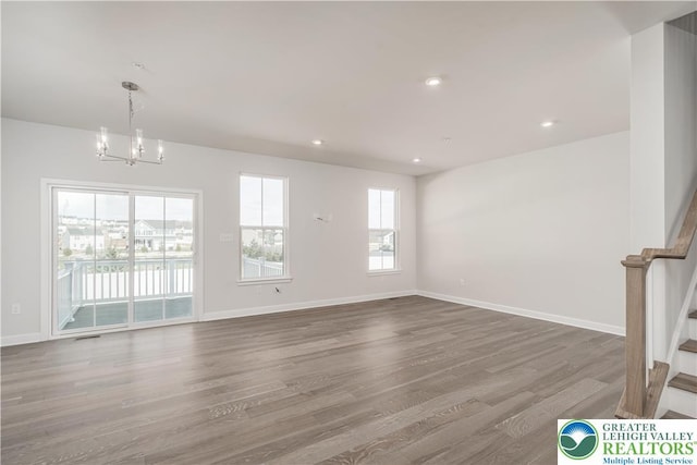 1022 Watson Ct, Upper Macungie Twp, PA 18051 - unfurnished living room with a chandelier, stairs, wood finished floors, and recessed lighting