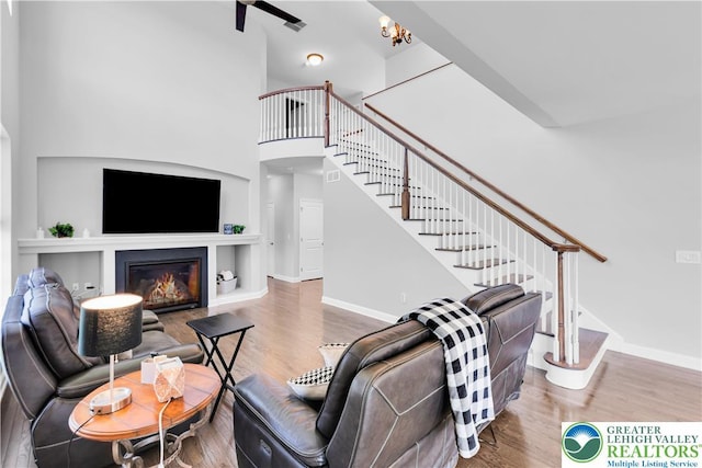 2835 Lenape, Forks Twp, PA 18040 - living area with stairs, wood finished floors, a high ceiling, ceiling fan, and a glass covered fireplace