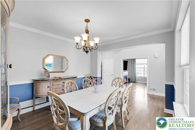 2835 Lenape, Forks Twp, PA 18040 - dining room with wood finished floors, crown molding, a chandelier, and a lit fireplace