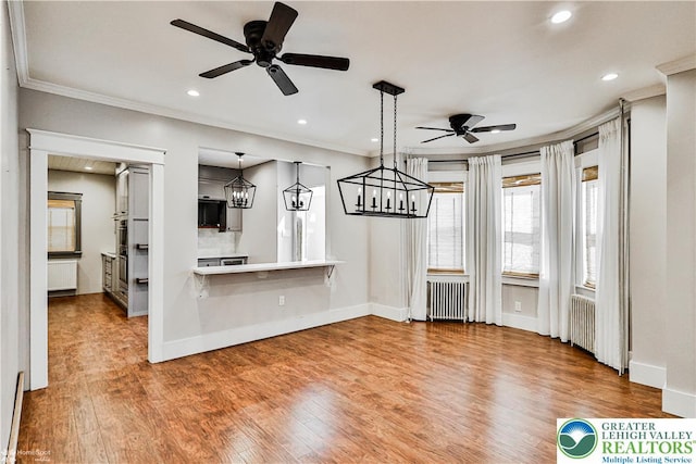 4711 Main St, Whitehall Twp, PA 18052 - unfurnished dining area with radiator heating unit, ceiling fan, wood finished floors, recessed lighting, and crown molding