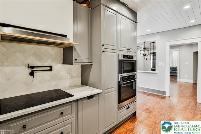4711 Main St, Whitehall Twp, PA 18052 - kitchen with black electric stovetop, gray cabinets, backsplash, light wood-style floors, and recessed lighting