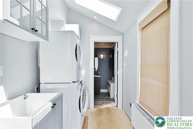 4711 Main St, Whitehall Twp, PA 18052 - laundry room with cabinet space, stacked washer / drying machine, radiator heating unit, and a skylight