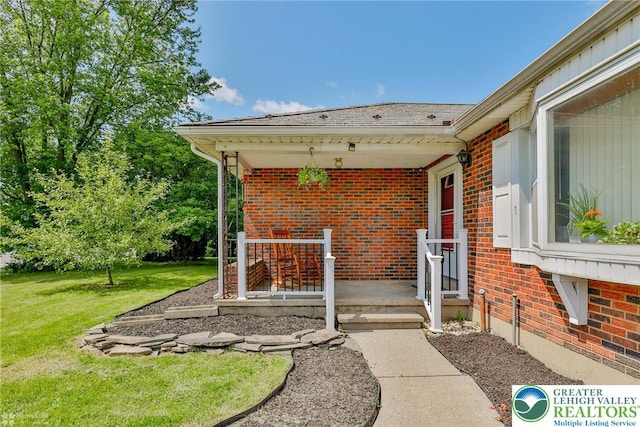 236 Moorestown Rd, Bushkill Twp, PA 18091 - doorway to property with brick siding, a yard, roof with shingles, and a porch