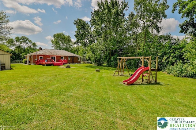 236 Moorestown Rd, Bushkill Twp, PA 18091 - view of green lawn with a playground, a wooden deck, and view of wooded area