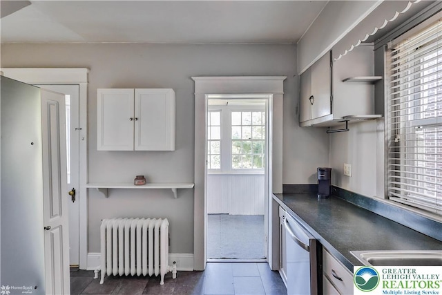 650 Highland Ave, Bethlehem City, PA 18018 - kitchen featuring radiator heating unit, dark countertops, white cabinetry, white dishwasher, and dark tile patterned floors