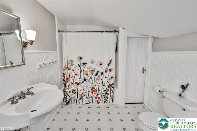650 Highland Ave, Bethlehem City, PA 18018 - full bath featuring wainscoting, curtained shower, lofted ceiling, and tile patterned floors