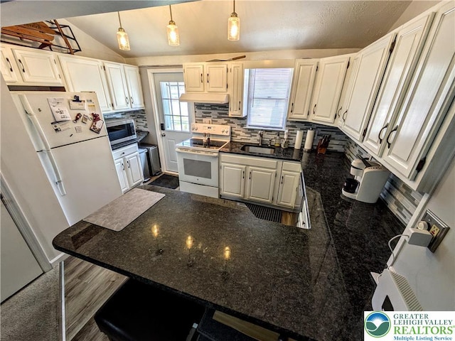 135 N 2nd St, Coplay Boro, PA 18037 - kitchen with white appliances, decorative backsplash, a peninsula, lofted ceiling, and hanging light fixtures
