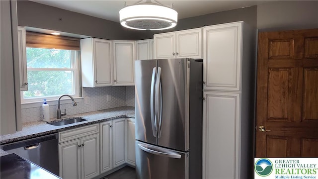 5278 Herman St, Heidelberg Twp, PA 18053 - kitchen featuring stainless steel appliances, white cabinetry, light stone counters, backsplash, and hanging light fixtures