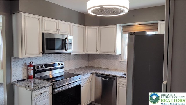 5278 Herman St, Heidelberg Twp, PA 18053 - kitchen with appliances with stainless steel finishes, tasteful backsplash, white cabinetry, and light stone countertops