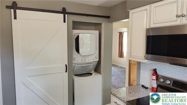 5278 Herman St, Heidelberg Twp, PA 18053 - laundry area featuring stacked washing machine and dryer, a barn door, and carpet