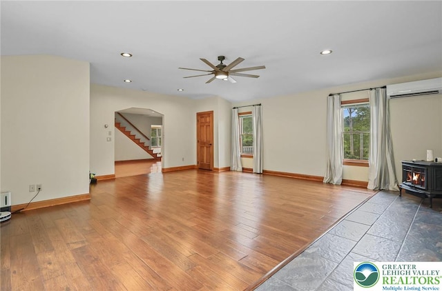 3224 Middle Easton Belmont Pike, Hamilton Twp, PA 18360 - unfurnished living room with a wall mounted AC, a wood stove, a ceiling fan, arched walkways, and recessed lighting