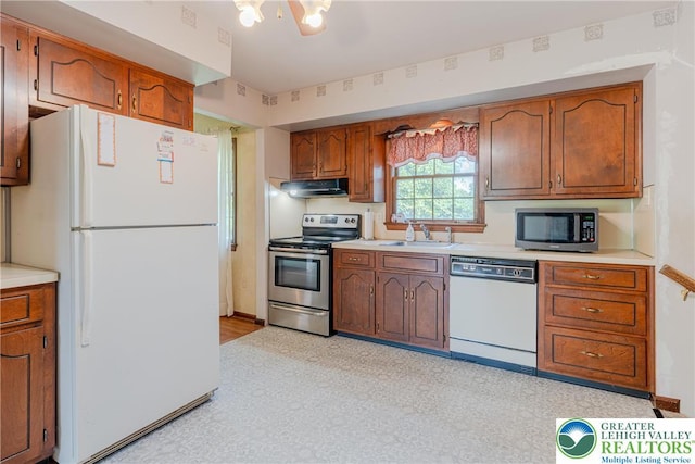 4834 Maple St, Lower Mt Bethel Twp, PA 18013 - kitchen featuring stainless steel appliances, under cabinet range hood, light countertops, and brown cabinets