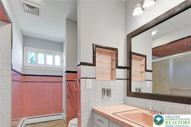 217 2nd St, Walnutport Boro, PA 18088 - full bathroom featuring tile walls, a baseboard radiator, vanity, a wainscoted wall, and a shower with door