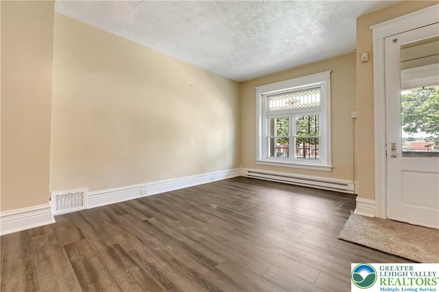 1744 W Chew St, Allentown City, PA 18104 - spare room featuring a baseboard heating unit, wood finished floors, healthy amount of natural light, and a textured ceiling
