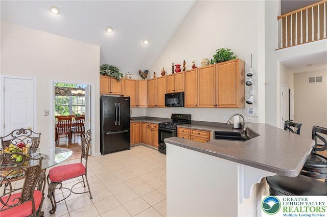 441 Sawgrass Dr, Upper Macungie Twp, PA 18104 - kitchen with black appliances, high vaulted ceiling, dark countertops, a peninsula, and a breakfast bar