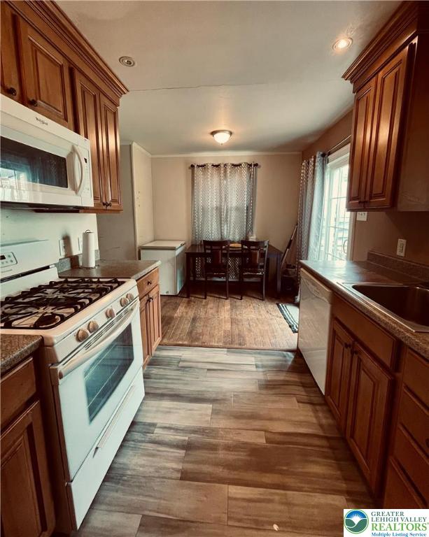 95 7th St, Whitehall Twp, PA 18052 - kitchen with white appliances, brown cabinetry, recessed lighting, light wood-style floors, and dark countertops