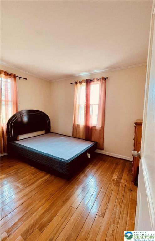 95 7th St, Whitehall Twp, PA 18052 - bedroom featuring multiple windows, light wood-type flooring, and crown molding