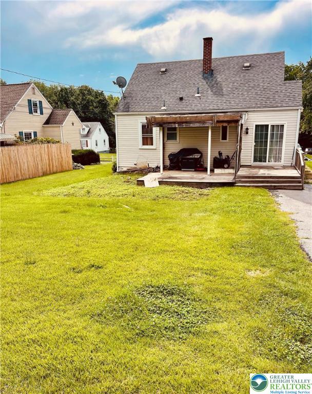 95 7th St, Whitehall Twp, PA 18052 - back of property with a deck, a jacuzzi, a chimney, and roof with shingles