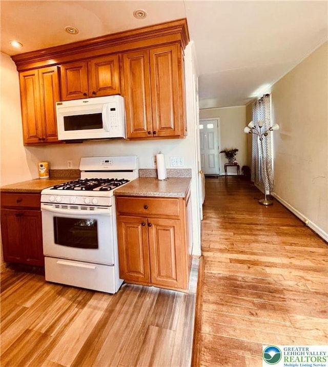 95 7th St, Whitehall Twp, PA 18052 - kitchen with white appliances, light wood-style floors, and brown cabinetry