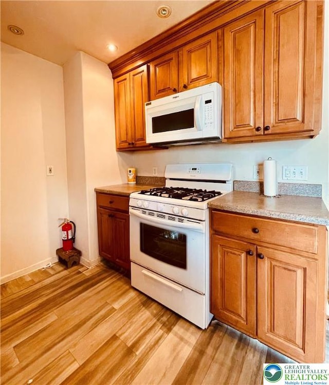 95 7th St, Whitehall Twp, PA 18052 - kitchen with white appliances, light wood-style flooring, brown cabinetry, recessed lighting, and light countertops