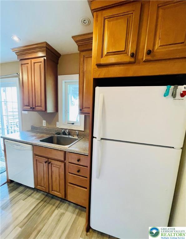 95 7th St, Whitehall Twp, PA 18052 - kitchen featuring white appliances, brown cabinets, light wood-type flooring, and light countertops