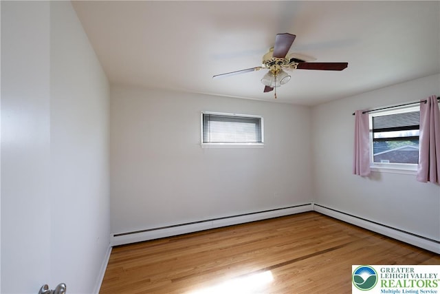 spare room with plenty of natural light, a baseboard heating unit, and light wood-style flooring