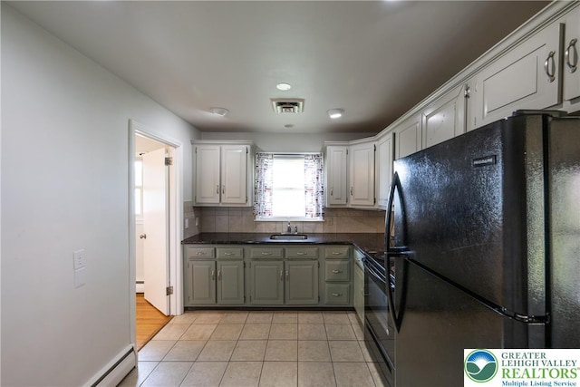 kitchen featuring black appliances, dark countertops, white cabinetry, backsplash, and light tile patterned flooring