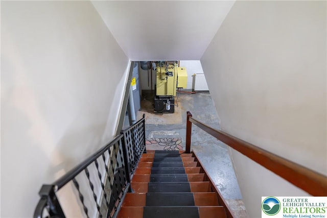 staircase featuring radiator and concrete floors