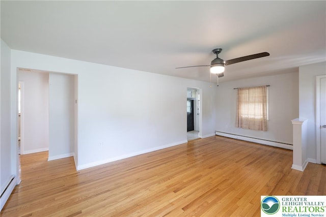 spare room with baseboard heating, a ceiling fan, and light wood-type flooring