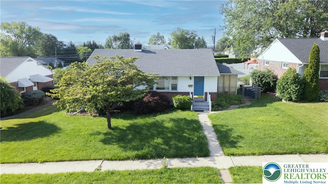 view of front of house with brick siding, a front lawn, and a shingled roof