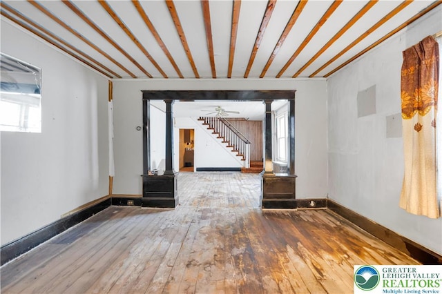 232 W Patterson St, Lansford Boro, PA 18232 - unfurnished room featuring hardwood / wood-style floors, stairway, a ceiling fan, and decorative columns
