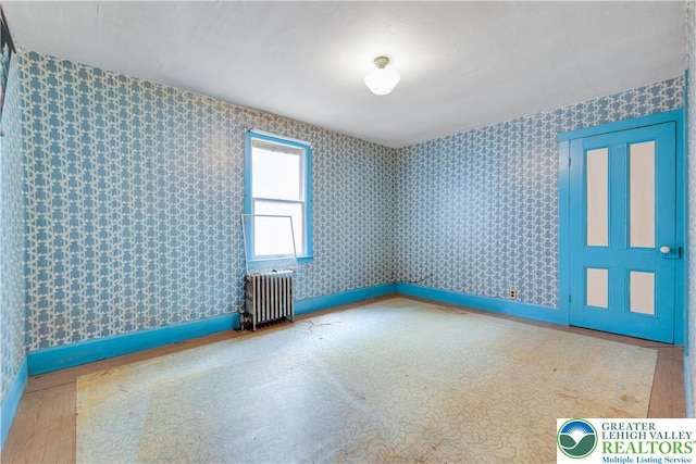 232 W Patterson St, Lansford Boro, PA 18232 - empty room with radiator heating unit, wallpapered walls, and wood finished floors