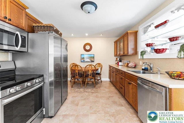 45 Wright St, Wilson Boro, PA 18042 - kitchen featuring appliances with stainless steel finishes, brown cabinetry, light countertops, glass insert cabinets, and recessed lighting