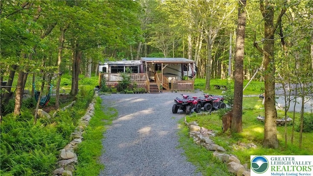 149 Deer Path Ln, Tobyhanna Twp, PA 18346 - view of yard featuring a deck, a forest view, and driveway