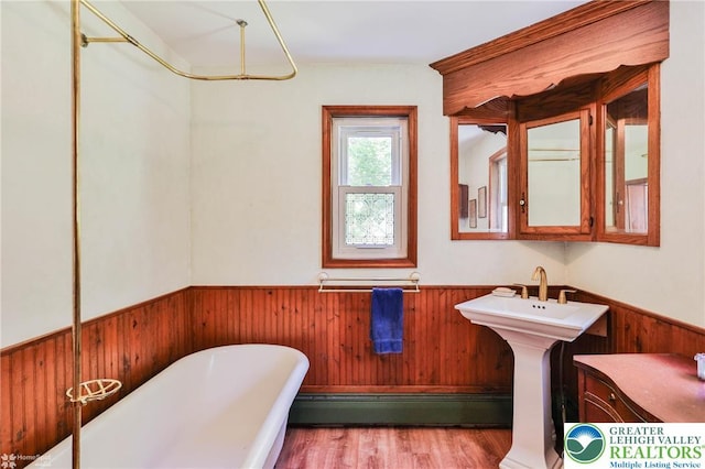 388 Kohls Rd, Allen Twp, PA 18067 - full bathroom featuring wainscoting, a freestanding bath, a baseboard radiator, wood walls, and wood finished floors