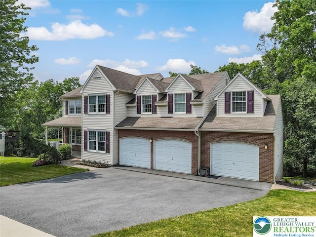 310 Spyglass Hill Rd, Bath Boro, PA 18014 - view of front of house with asphalt driveway, an attached garage, brick siding, and a front lawn