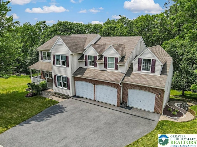 310 Spyglass Hill Rd, Bath Boro, PA 18014 - view of front of house with asphalt driveway, brick siding, an attached garage, a front lawn, and covered porch