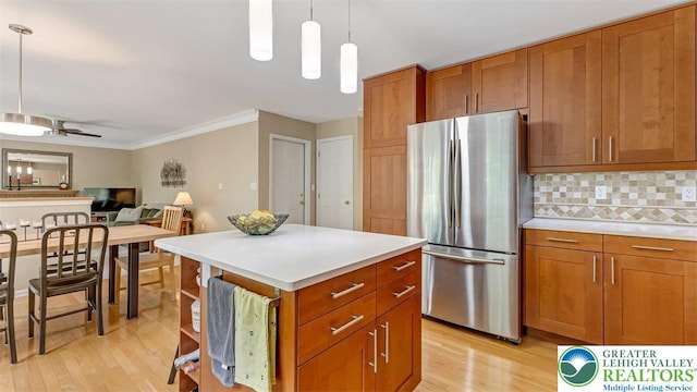 310 Spyglass Hill Rd, Bath Boro, PA 18014 - kitchen with freestanding refrigerator, light wood-type flooring, brown cabinetry, decorative backsplash, and crown molding