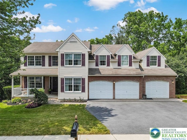 310 Spyglass Hill Rd, Bath Boro, PA 18014 - view of front of house featuring asphalt driveway, a garage, a front yard, and brick siding