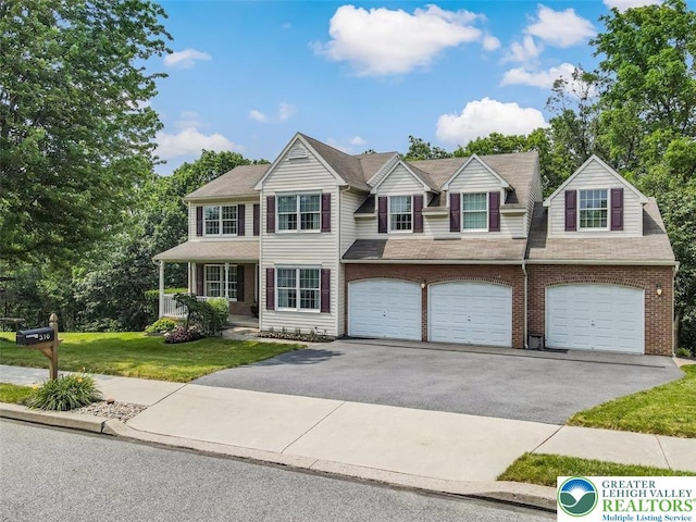 310 Spyglass Hill Rd, Bath Boro, PA 18014 - view of front facade featuring driveway, a front yard, a garage, and brick siding