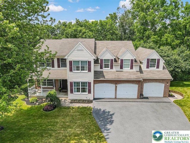 310 Spyglass Hill Rd, Bath Boro, PA 18014 - view of front of house with asphalt driveway, a front yard, an attached garage, and covered porch