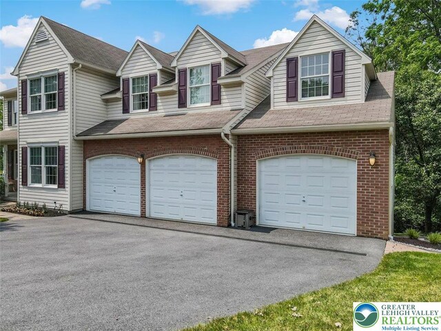 310 Spyglass Hill Rd, Bath Boro, PA 18014 - view of front facade with an attached garage, asphalt driveway, brick siding, and a shingled roof