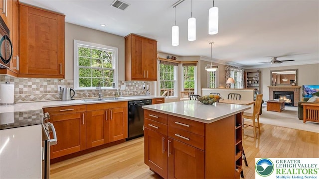 310 Spyglass Hill Rd, Bath Boro, PA 18014 - kitchen with black appliances, light wood-style flooring, decorative backsplash, a fireplace, and brown cabinets