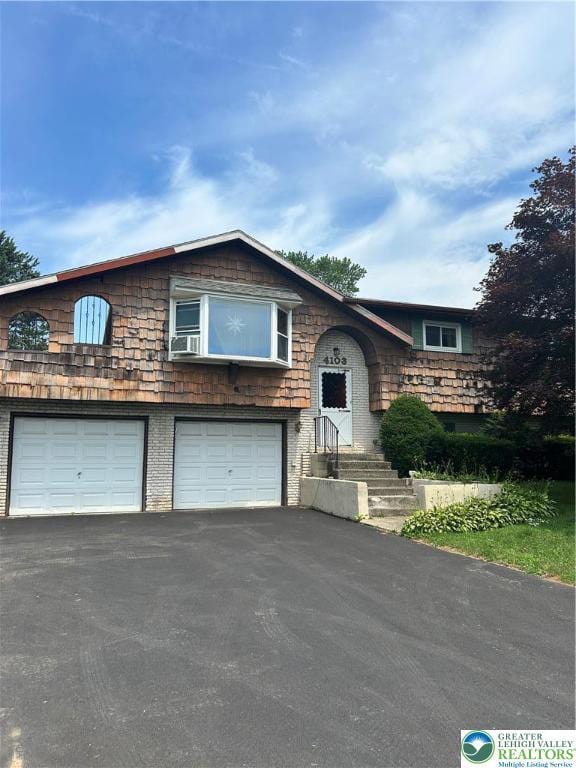4103 Birch Dr, Bethlehem City, PA 18020 - split foyer home with an attached garage, asphalt driveway, brick siding, and cooling unit