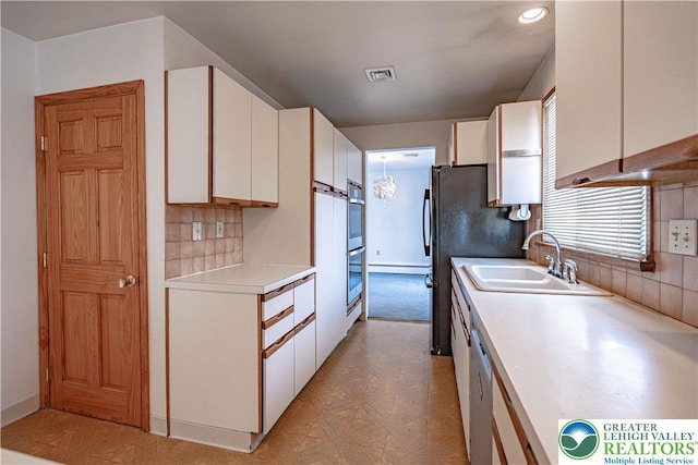 3442 Hickory Cir S, Whitehall Twp, PA 18103 - kitchen with white cabinets, light countertops, decorative backsplash, baseboard heating, and stainless steel double oven