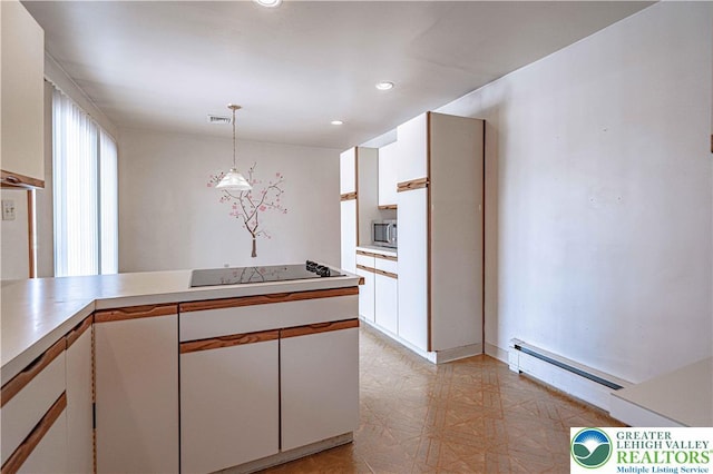 3442 Hickory Cir S, Whitehall Twp, PA 18103 - kitchen with stainless steel microwave, a baseboard radiator, black electric cooktop, hanging light fixtures, and light countertops